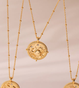 18k gold plated brass Cancer star sign Zodiac Necklace with cubic zirconia stones and intricate detailing on a coin disc pendant and on fine ball chain.