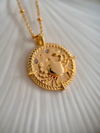 18k gold plated brass Cancer star sign Zodiac Necklace with cubic zirconia stones and intricate detailing on a coin disc pendant and on fine ball chain.