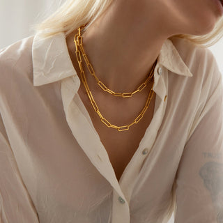 18k Gold plated Paperclip link Chains from brand Gold Lunar worn on a model wearing an open semi sheer white shirt.