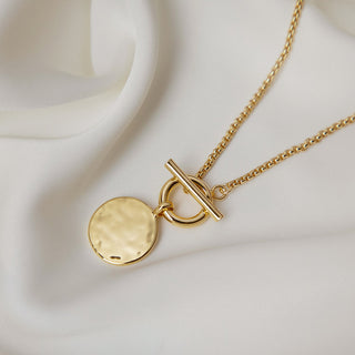 gold plated T Bar & Disc Necklace - Gold Lunar displayed on a cream satin fabric