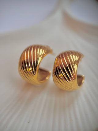 18k gold plated chunky hoops with etched design on a white jewellery dish