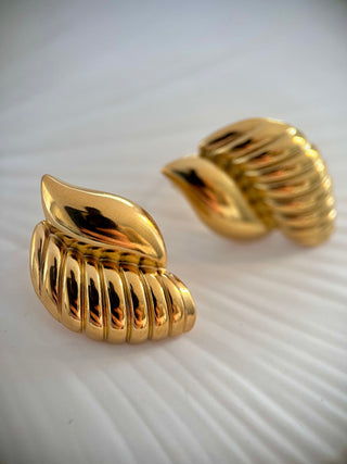 18k gold plated curve studs with ribbed detail displayed on a white jewellery dish