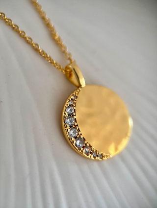 18k gold plated celestial moon disc with Cubic Zirconia stones in a crescent moon shape on a hammered molten disc on fine chain necklace