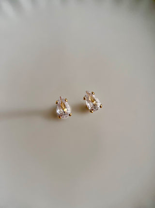 Cubic zirconia dainty teardrop stud earrings in 18k gold plated brass displayed on jewellery dish