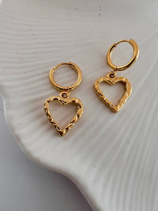 18k gold plated molten heart hoop earrings displayed on a modern white jewellery dish