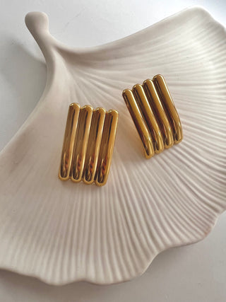 Large Ridge Studs 18k gold plated earrings displayed on white jewellery dish