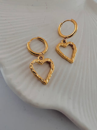 18k gold plated molten heart drop charm earrings on a fine hoop huge earring displayed on a white jewellery dish