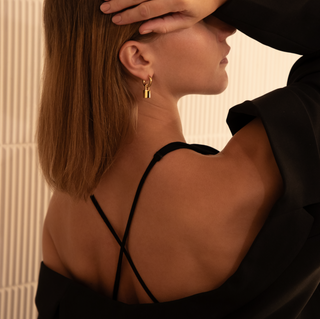 18k gold plated chubby hoop with padlock charm worn on model wearing a black top and Zara black blazer worn off the shoulder