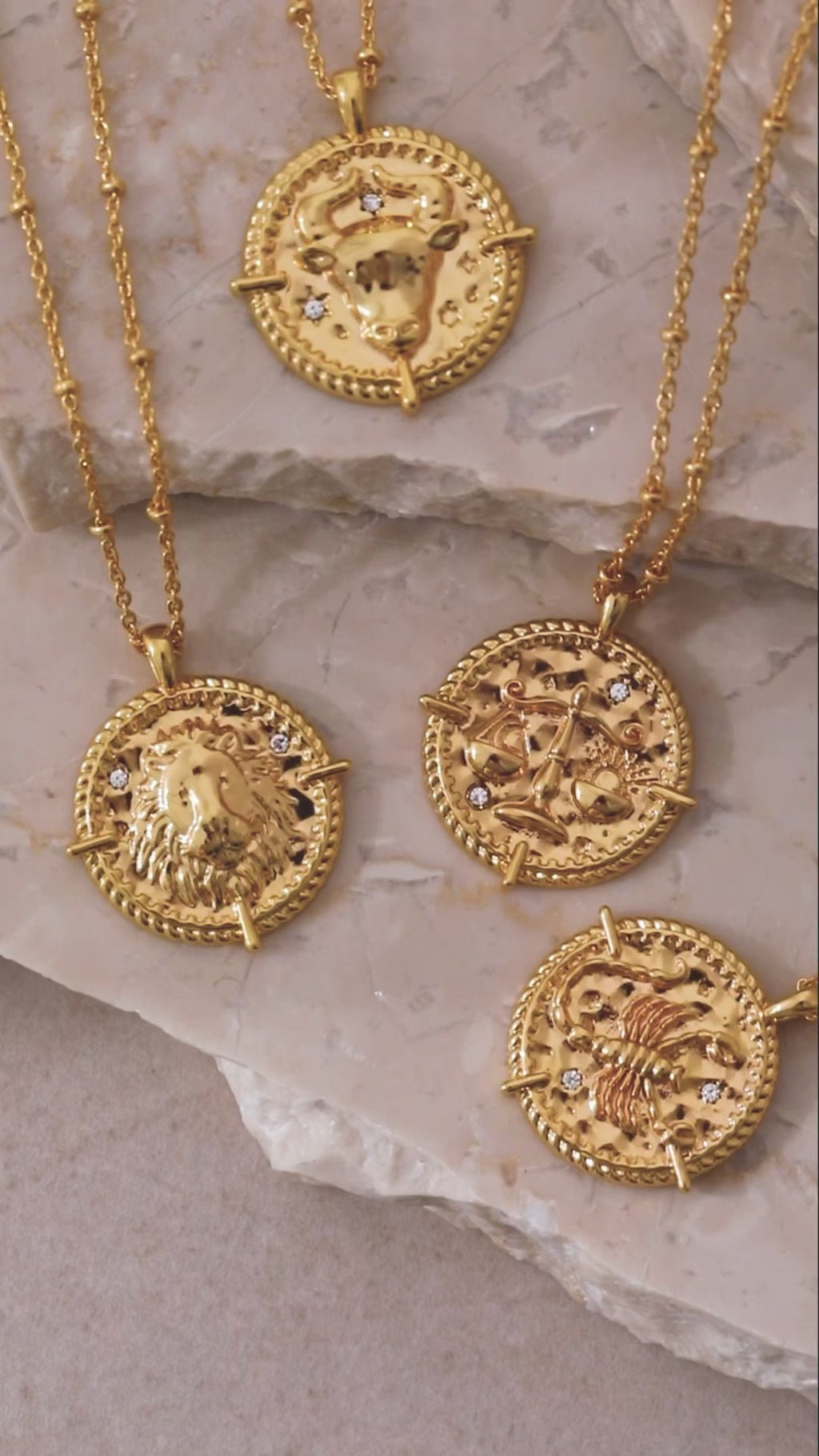 Zodiac necklace collection on concrete tiles