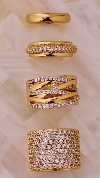 multiple gold plated rings in a line on a mother of pearl dish