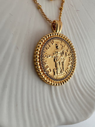 18k gold plated two coin necklace with cubic zirconia stones around the disc and an antique style roman man and roman letters around the edge of the coin.