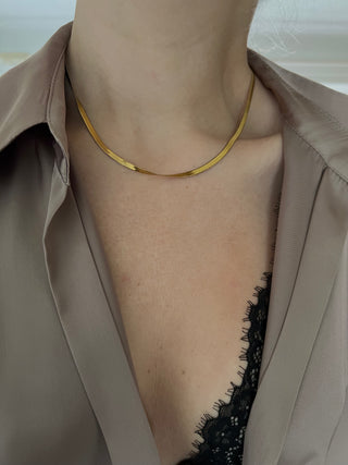 gold plated snake chain worn by model wearing a ZARA brown silk shirt open at the front exposing black lace bra trim