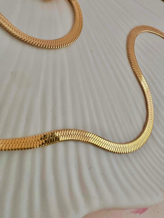 gold plated snake chain on white dish