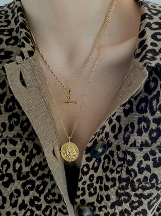 18k gold plated T Bar pendant on a rope Twist Chain Necklace worn on a model wearing a leopard print knitted cardigan from Sezane, layered with a 18k gold plated coin necklace.