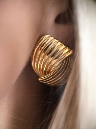 18k gold plated wrap over stud earrings with ribbed detailing worn on a model with blond hair