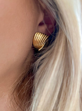 18k gold plated wrap over stud earrings with ribbed detailing worn on a model with blond hair that waves around the ear